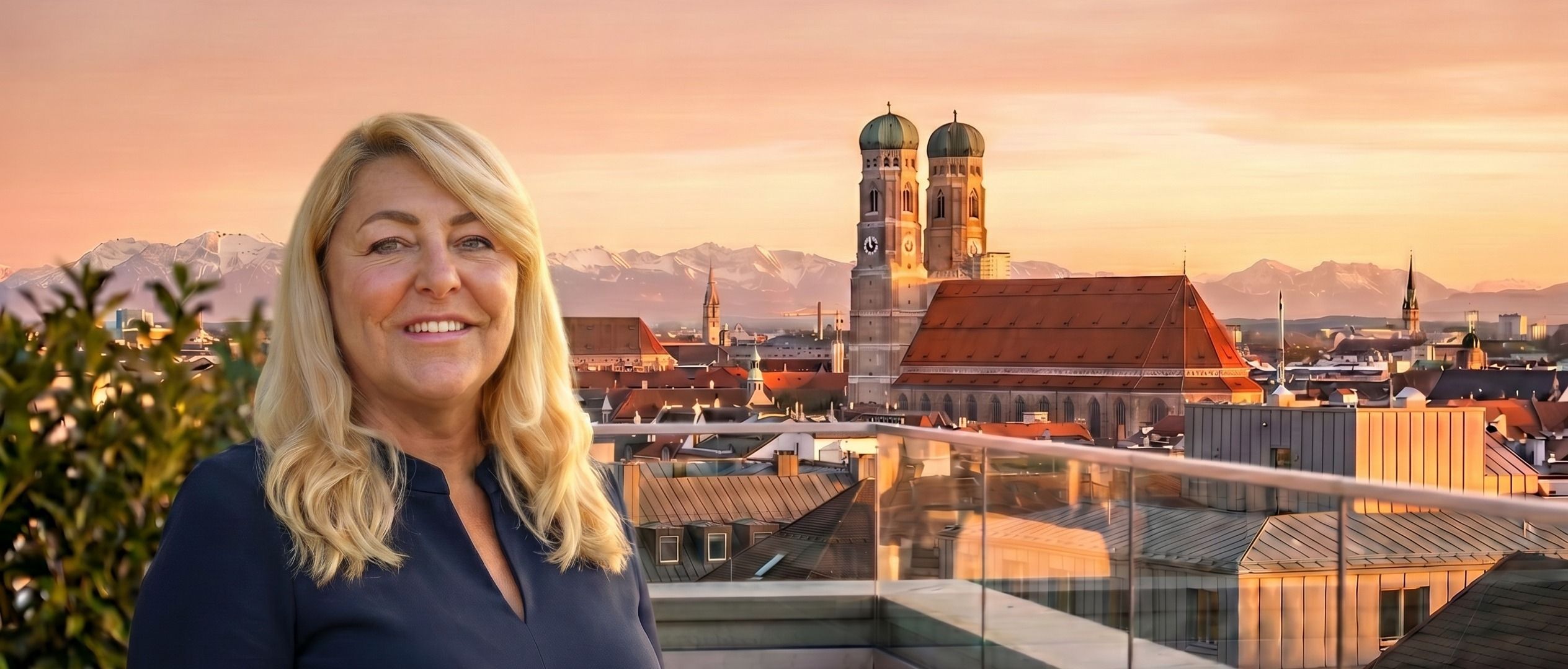 Uta Herzberg am Abend auf einer Dachterrasse über München — im Hintergrund die Türme der Frauenkirche